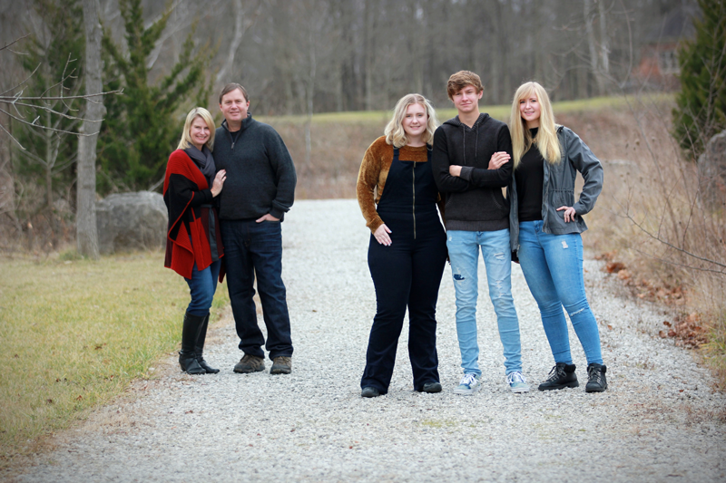 Caucasian adult child & parent posing in a picture together as a family.